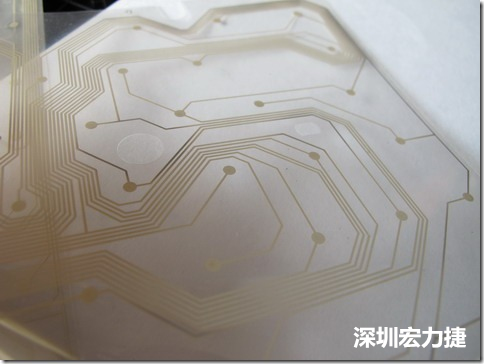 下面第二個(gè)圖則是另一片也有著按鍵線路的PTF，當(dāng)上、下兩面PTF的按鍵結(jié)點(diǎn)互相接觸后就可以計(jì)算出是哪個(gè)按鍵被按下了?？墒钱?dāng)按鍵沒有按下時(shí)，上下兩片PTF的線路則是分開的，所以上圖那片PTF的線路上面其實(shí)還另外覆蓋了另一層透明的PET作為絕緣層，只露出了需要在鍵盤按下時(shí)才會(huì)碰觸的接觸點(diǎn)，因?yàn)檫@些材質(zhì)使用的都是Polymer，所以才撐這樣的技術(shù)為Polydome(聚合簧片)。